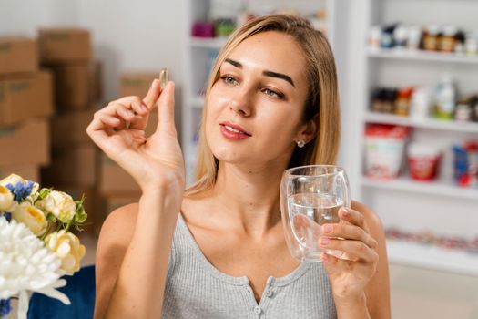 Girl with Omega 3 pill of fish fat oil in hands. BADS capsule of biologically active dietary supplements. Vitamin D for building and maintaining healthy bones