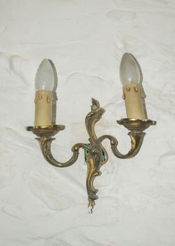 Antique candlesticks with candles hanging on the wall