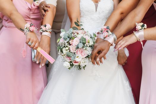 Bride with a bouquet and bridesmaids in identical dresses and bracelets