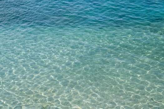 Seawater surface, sun's rays shimmer on water surface, top view