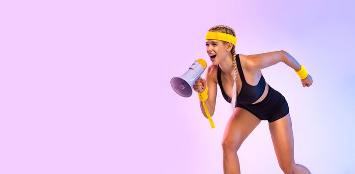 Two Emotional Women in Sportswear Screaming Using Megaphone. Social issues, protest concept. A girls speaks into a speaker about an upcoming promotion and discounts in fitness store.