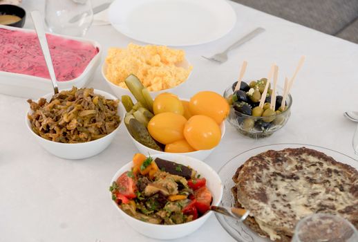 many delicious dishes on the festive table, family dinner, table setting, traditional marinade, tomatoes and salads, liver pie, high quality photo