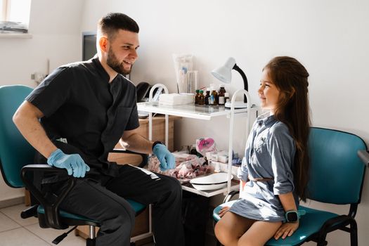 Consultation of kid with a pediatric otolaryngologist in a medical clinic. Nose examination of the child