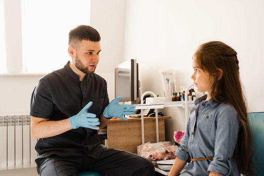 Consultation of kid with a pediatric otolaryngologist in a medical clinic. Nose examination of the child