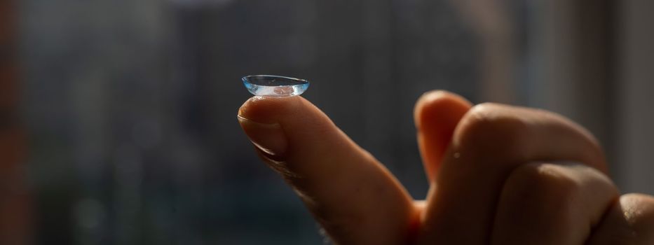 Close-up of a contact lens on a woman's index finger