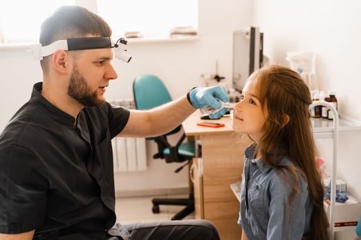 Rhinoscopy of child nose. Consultation with doctor. Children otolaryngologist examines child nose before procedure of endoscopy of nose