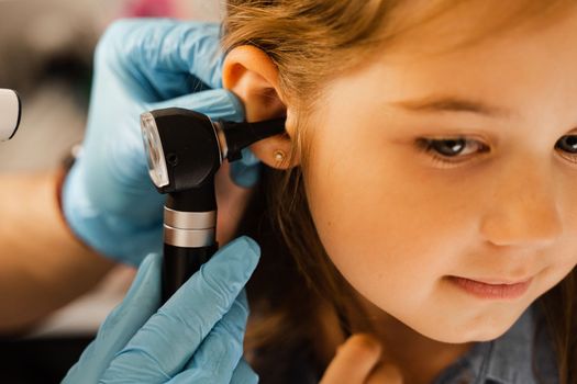 Close-up examination of childs ear with otoscope. Otoscopy. Visit to ENT doctor and consultation