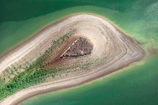 Aerial view of island with green plants surrounded by sea or ocean with clear water. Colorful landscape with beautiful nature. Tourism, traveling.