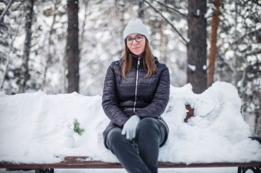 Woman in winter jacket walking in snowy winter forest, snowy winter day. Funny situation, woman fell down and laughs