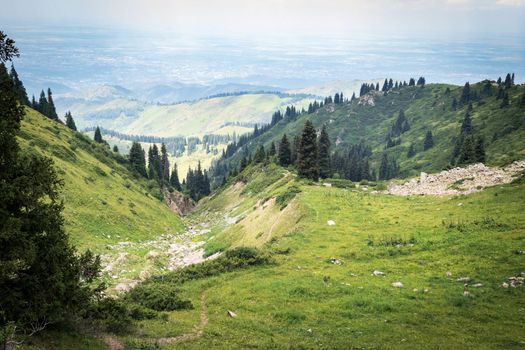 View of the city of Almaty from the hiking trail to Mount Furmanov along the Kimasar gorge, in the Almaty mountains. Tourist natural places of Kazakhstan.