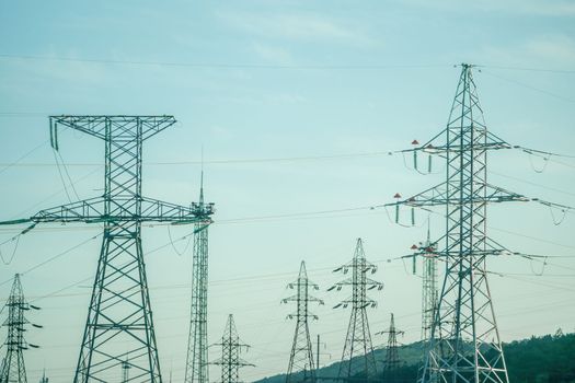 Silhouette High voltage electric tower on sunset time, distribution electric substation with power lines and transformers.