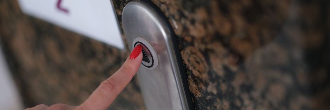 Female finger with presses elevator button. Servicing elevators concept