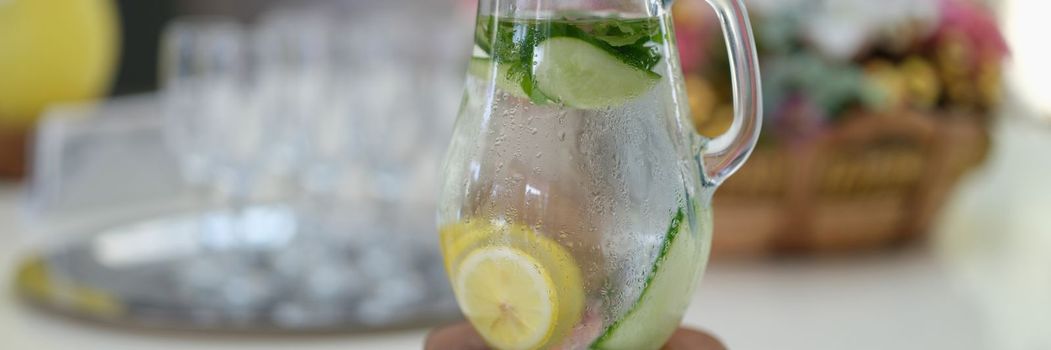 Jug of cold cucumber lemonade on table. Cool summer drink concept