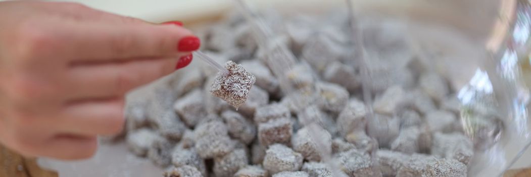 Woman hand takes sweet Turkish delight. Sweet tasty marmalade concept