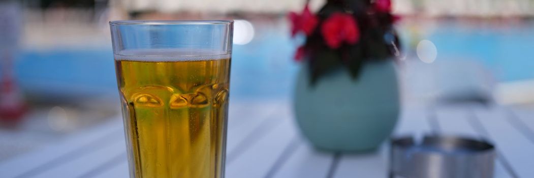 Glass of tea or beer on table in evening. Evening tea party concept