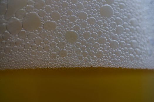 close-up of beer foam with bubbles with selective focus