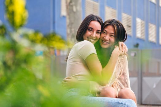 portrait of a young female couple embracing and looking at camera, concept of friendship and love between people of the same sex, copy space for text