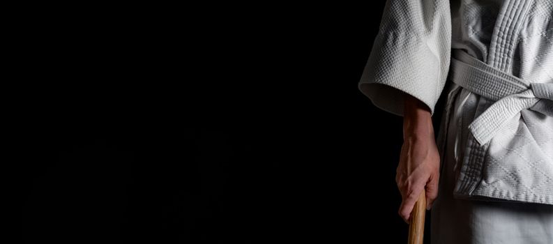 A person practicing aikido martial art on a black background.