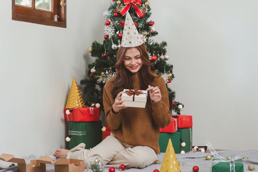 Cheerful lady surprised of the present after the opening in the gift box. Marry Christmas and Happy Holidays and New Year eve celebrating concept.