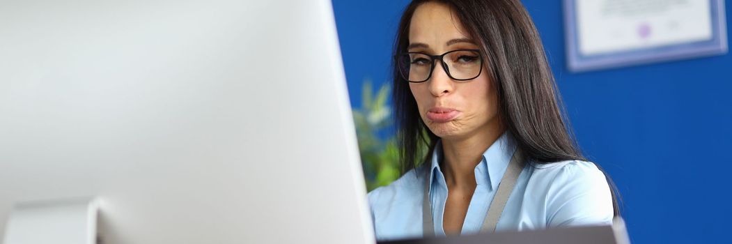 Offended woman works on computer in office. Emotions and business mistake concept
