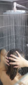 woman takes cool shower and washes hair. Body hygiene concept