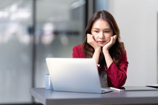 asian woman thinking hard concerned about online problem solution looking at laptop screen, worried serious asian businesswoman focused on solving difficult work computer task..