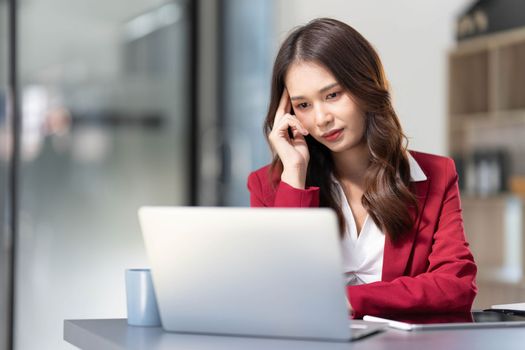 asian woman thinking hard concerned about online problem solution looking at laptop screen, worried serious asian businesswoman focused on solving difficult work computer task..