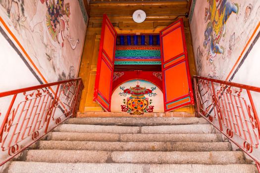 Stairs leading to a painted door of a Tibetan prayer hall at Kumbum Champa Ling Monastery near Xining, China