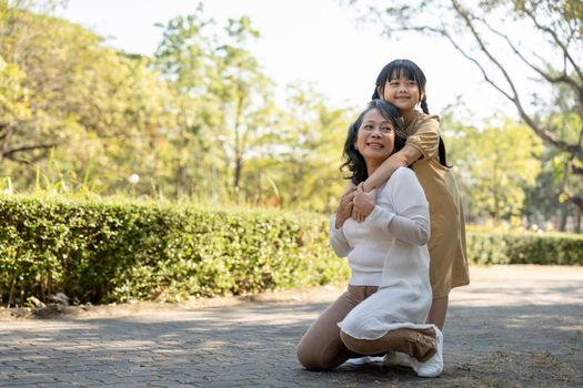 Happy granddaughter and her grandmother at summer park, family, leisure and people concept.