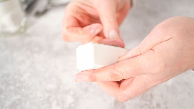 Woman finishing her manicure at home with simple manicure tools. Buffering nails with a nail buffer block.