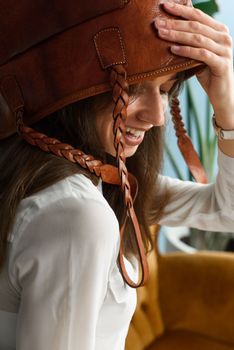 close-up photo of orange leather bag on a womans had. indoor photo. beautiful girl in a white blouse having fun with a handbag