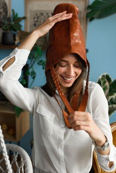 close-up photo of orange leather bag on a womans had. indoor photo. beautiful girl in a white blouse having fun with a handbag