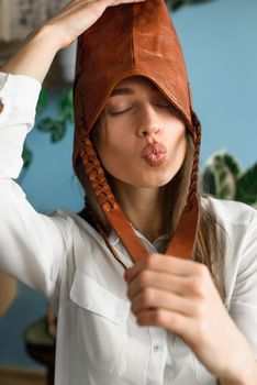 close-up photo of orange leather bag on a womans had. indoor photo. beautiful girl in a white blouse having fun with a handbag