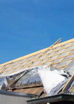 House thermal insulation with mineral wool, roof insulation technique. construction old roof from house blue sky