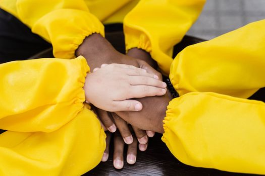 Multiracial children hands together forming pile close-up. Friendship of multinational kids. Childhood