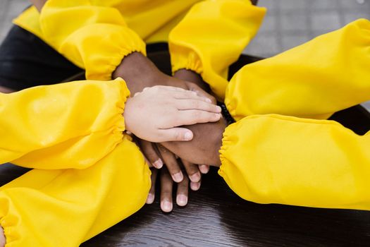 Multiracial children hands together forming pile close-up. Friendship of multinational kids. Childhood