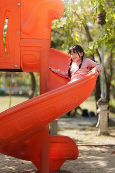 Happy Asian children playing at playground at outdoor park.
