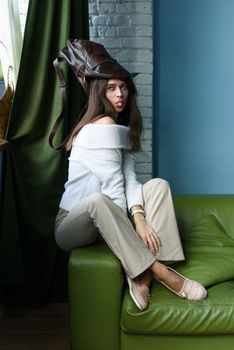 close-up photo of a brown leather bag on a womans had. indoor photo. beautiful girl in a white blouse having fun with a handbag