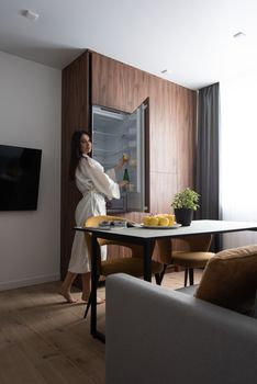 a woman in the kitchen takes food from the refrigerator. apartment after renovation. housing in mortgage