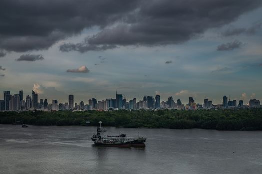 Bangkok, Thailand - Jun 24, 2019 : View of the sky, boats and buildings in the Chao Phraya River at sunset.