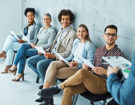 Group of young businss people sitting in chairs and waiting for an interview