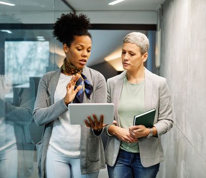 Portrait of two young business woman having a meeting or presentation and seminar standing in the office. Portrait of a young business woman talking