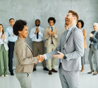 Group of young and senior business people having a meeting shaking hands handshake introducing each other in the office. Teamwork and success concept