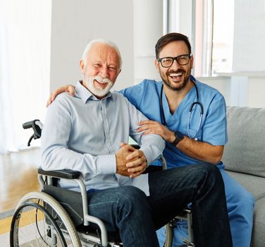 Doctor or nurse caregiver helping senior man in a wheelchair at home or nursing home