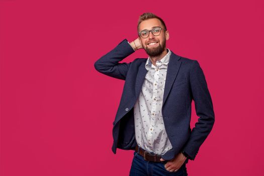 Studio shot of attractive brunette business man with glasses, in casual shirt, stylish black jacket talking, smiling. Isolated pink background.