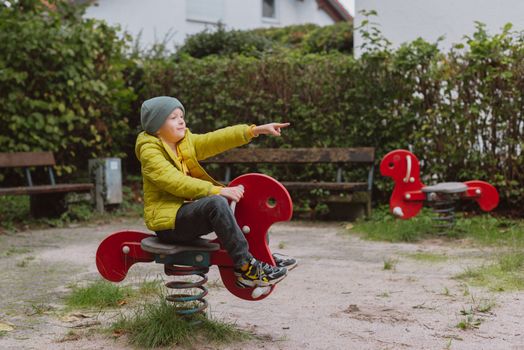 Funny cute happy baby playing on the playground. The emotion of happiness, fun, joy. Smile of a child. boy playing on the playground.