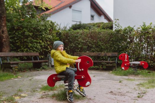 Funny cute happy baby playing on the playground. The emotion of happiness, fun, joy. Smile of a child. boy playing on the playground.