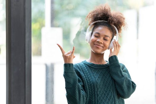 Portrait of smiling young black woman listening music with headset and digital tablet..