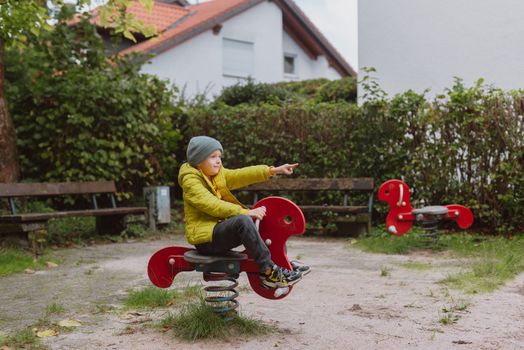 Funny cute happy baby playing on the playground. The emotion of happiness, fun, joy. Smile of a child. boy playing on the playground.