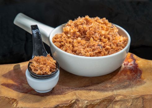 Shrimp paste with Dried shrimps in white Ceramic Bowl on Wooden plank. Copy space, Selective focus.